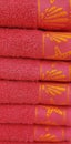 red bath towels folded and stacked on a shelf