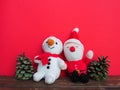 Plush sewn Christmas soft toys on a red background. Painted cones. A little smiling snowman and a funny Santa Royalty Free Stock Photo