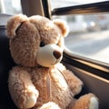 Plush teddy bear sitting in a bus at the window - travel concept