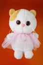 Plush white cat on an orange background