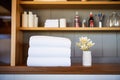 plush white towels stacked on a wooden shelf