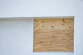Plywood board covering a window in preparation for a hurricane Royalty Free Stock Photo