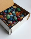 Plywood box with open lid half filled with translucent colored mineral stones Royalty Free Stock Photo