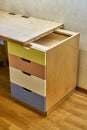 Plywood desk with multi color drawers during assembly