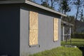 Plywood mounted as storm shutters for hurricane protection of house windows. Protective measures before natural disaster Royalty Free Stock Photo