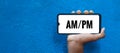 AM/PM word on smart phone screen isolated on blue background with copy space for text. Anti Meridiem / Post Meridiem Royalty Free Stock Photo