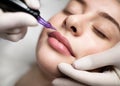 PMU Concept. Permanent Makeup Artist Doing Lip Blushing Procedure To Young Woman Royalty Free Stock Photo