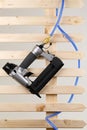 Pneumatic nailer and pressure hose isolated on a wooden paling