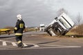 Firefighters at the accident scene with an overturned car in the background Royalty Free Stock Photo