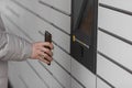 Man with smartphone entering QR code to open shopping locker. Caption: Read the QR code here and pick it up faster. Royalty Free Stock Photo