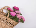 Pnk autumn flowers in a straw basket Royalty Free Stock Photo