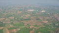 The Po Valley in Italy from the plane window during the landing of the airplane. Agricultural fields with green and brown colors