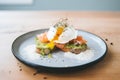 poached egg atop smashed avocado toast with cracked salt