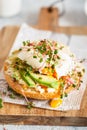 Poached egg with avocado, ricotta cheese and radish sprouts on burger bun. Healthy sandwich with bread, fresh avocado, poached egg Royalty Free Stock Photo