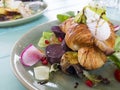 Poached egg on croissant with smoked bacon and salad.eggs benedict breakfast. Royalty Free Stock Photo