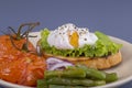 Poached egg on a piece of bread with fried green beans, tomato and arugula on a plate Royalty Free Stock Photo