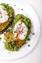 Poached eggs with avocado guacomole on brown bread with sesame seeds. Healthy breakfast on a white background. Royalty Free Stock Photo