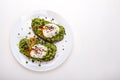 Poached eggs with avocado guacomole on brown bread with sesame seeds. Healthy breakfast on a white background. Copy Royalty Free Stock Photo