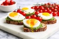 poached eggs on avocado toast with cherry tomatoes on a marble slab Royalty Free Stock Photo