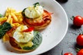 Poached eggs with french fries and bacon on toast Royalty Free Stock Photo