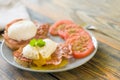 Poached eggs served on toast with bacon and tomato and herbs Royalty Free Stock Photo