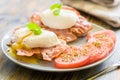 Poached eggs served on toast with bacon and tomato and herbs Royalty Free Stock Photo