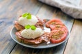 Poached eggs served on toast with bacon and tomato and herbs Royalty Free Stock Photo