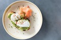 Poached eggs on top of smashed avocado on sourdough toast with smoked salmon. Healthy breakfast with plate on table. Top view.