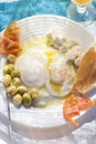 Poached fried eggs with goat`s cheese, tomatoes and olives, Moroccan breakfast