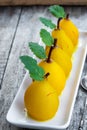 Poached pears with spices in a serving dish on wooden table Royalty Free Stock Photo