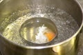 Poaching fresh eggs in a pan of water in an authentic kitchen environment. Royalty Free Stock Photo