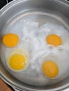 Poaching fresh eggs in a pan of water. Royalty Free Stock Photo