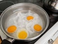 Poaching fresh eggs in a pan of water. Royalty Free Stock Photo