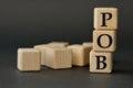 POB - acronym on wooden cubes on a dark background