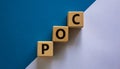 POC, proof of concept symbol. Wooden cubes with the word POC, proof of concept. Beautiful white and blue background. Business and Royalty Free Stock Photo