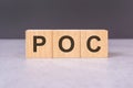 POC - text from wooden blocks with letters, front view on black background