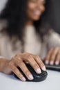 Close up photo of black woman`s hand clicking with mouse while doing work on computer Royalty Free Stock Photo