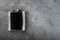 Pocket flask in leather finish with a drink on a dark background with copy space Royalty Free Stock Photo