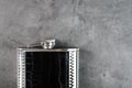 Pocket flask in leather finish with a drink on a dark background with copy space Royalty Free Stock Photo