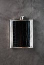 Pocket flask in leather finish with a drink on a dark background with copy space Royalty Free Stock Photo