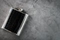 Pocket flask in leather finish with a drink on a dark background with copy space Royalty Free Stock Photo