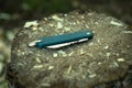 Pocket, folding knife blue color lies on a wooden piece of wood in the shavings..