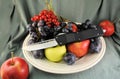 Pocket folding knife and fresh organic ripe fruits apples grape plums berries natural gourmet product dessert background