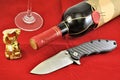 Pocket folding knife stainless blade carbon handle wine glass red background