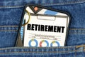 In a pocket of jeans there is a smartphone on the screen of which the text - RETIREMENT