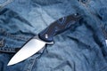 Pocket knife with a blue handle. Knife and jeans Royalty Free Stock Photo