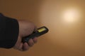 Pocket led flashlight in hand. illuminates brown background. Copy space Royalty Free Stock Photo