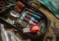 Open first aid kit with drugs and medical instruments on olive textile background. First aid in an emergency