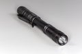 Pocket tactical electric LED mini flashlight on a gray background Royalty Free Stock Photo