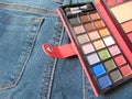 Pocket travel makeup palette on jeans Royalty Free Stock Photo